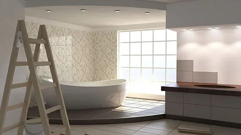 Lyst bad under oppussing med badekar, fliser og stige ved vindu.