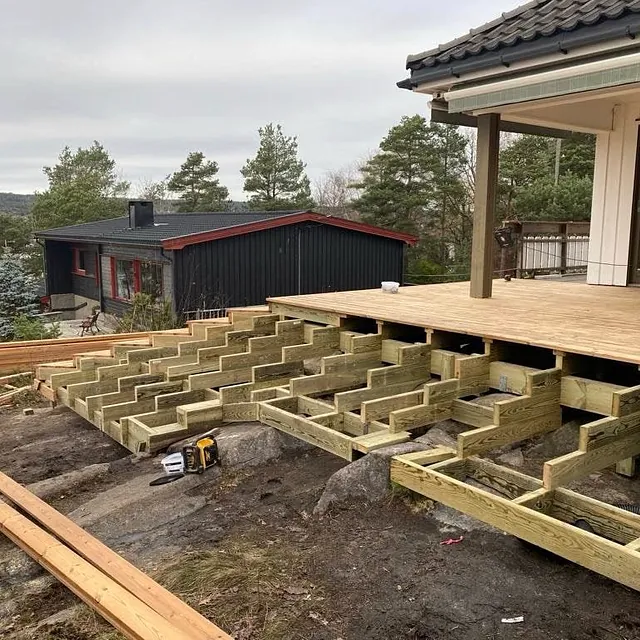 Bygging av ny terrasse med bjelkelag i tre utenfor enebolig.