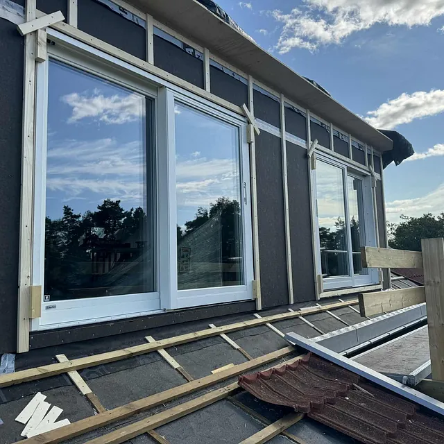 Uisolert yttervegg med nye vinduer og lekter på taket.