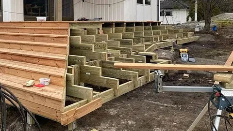 Terrassekonstruksjon i arbeid med nytt rekkverk og kledning montert.