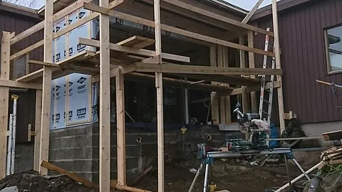 Påbygg i reisverk med stillas og verktøy utenfor enebolig.